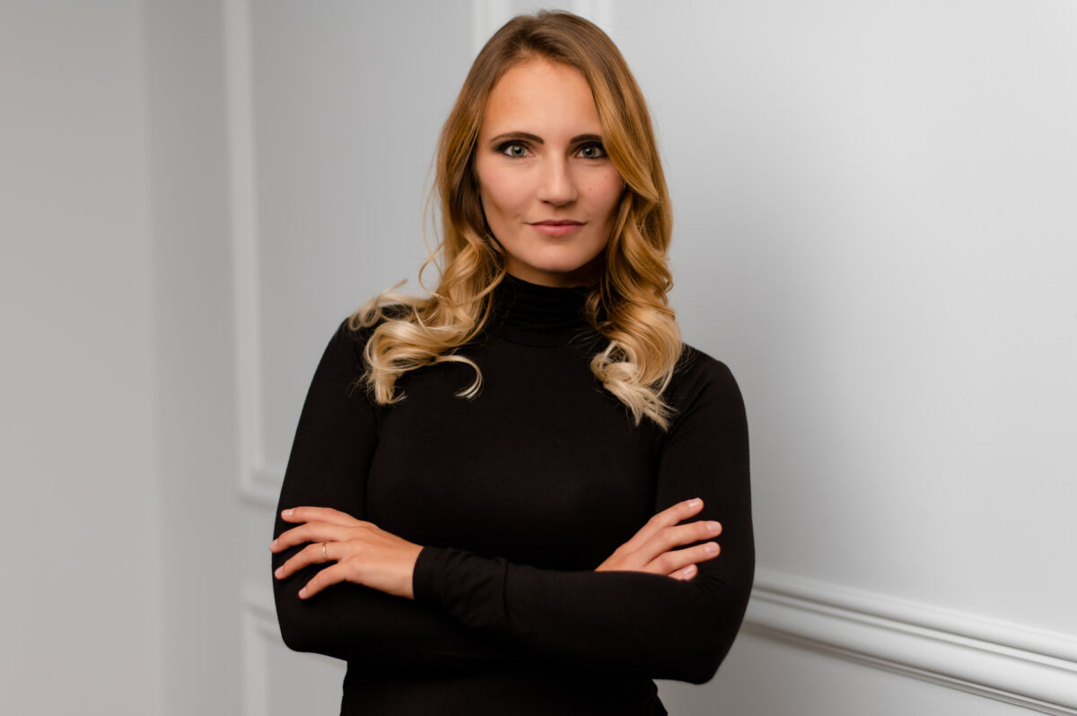 Christian Lorenz Fotograf Eine Frau mit langen, gewellten blonden Haaren und einem schwarzen Rollkragenpullover steht mit verschränkten Armen da und blickt selbstbewusst in die Kamera vor einem schlichten weißen Hintergrund. Christian Lorenz Fotograf Eine Frau mit langen, gewellten blonden Haaren und einem schwarzen Rollkragenpullover steht mit verschränkten Armen da und blickt selbstbewusst in die Kamera vor einem schlichten weißen Hintergrund.